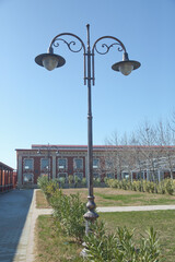 Vintage street light.black street lamp in an open blue sky . Street lantern on background blue sky . Old street light.