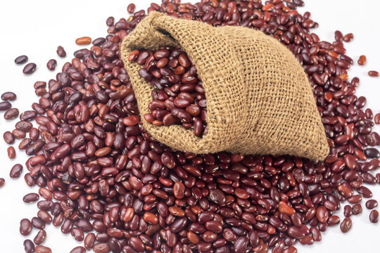 Fresh organic red kidney beans or rajma in a sackcloth bag on white background.