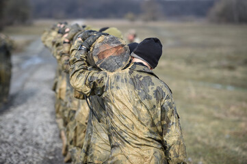 Special forces military training carrying a big log. Photograph detail with military equipment and...