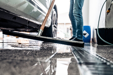Clean the floor at the car wash with the help of a water spatula