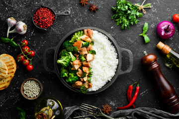 Boiled rice with broccoli and chicken fillet. In a frying pan. Healthy food. Top view.