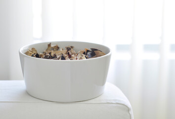 A contemporary white bowl filled with aromatic potpourri.