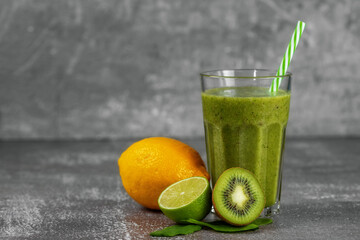 Fresh healthy smoothie drink in a tall glass glass with fruits on gray