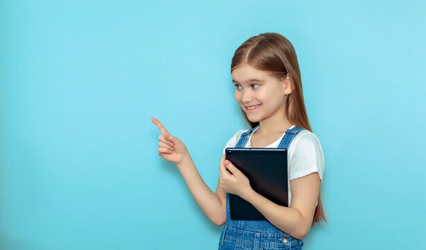 Horny teen girl with tablet pointing finger isolated on blue background