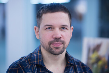 Obraz premium Portrait of a young man in a shirt and jeans indoors.