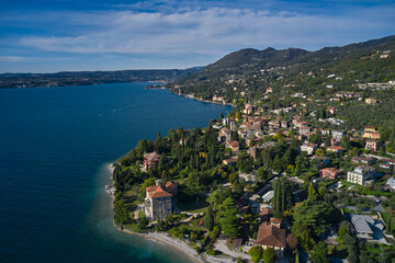 Fototapeta premium Panoramic view of the historic city of Toscolano Maderno on Lake Garda Italy. Tourist place on Lake Garda in the background Alps and blue sky. Aerial view of the town on Lake Garda.