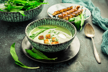 Bear leek soup or ramson soup with crouton, sour cream and turkey skewer