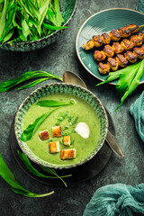Bear leek soup or ramson soup with crouton, sour cream and turkey skewer