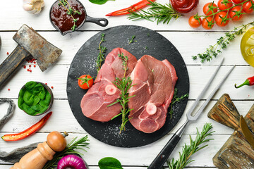Meat. Raw boneless lamb steak with rosemary and spices. On a white wooden background. Top view.