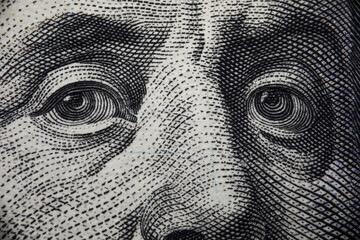 Close-up of benjamin franklins face on hundred banknote