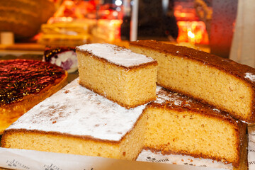 Sponge cake cut in the display case ready for sale, food concept