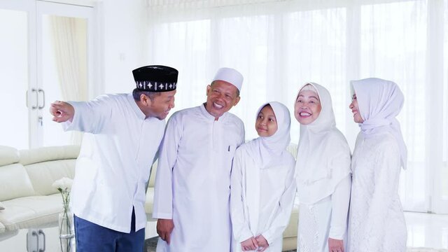 Three generation Muslim family look at something
