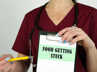 Medical concept meaning FOOD GETTING STUCK with phrase on the page.
