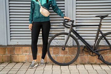 Lady in black leggings holding the bicycle handlebar