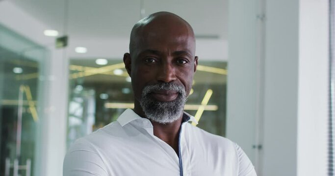 Portrait of smiling african american businessman in white shirt standing in office