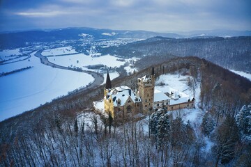 
Luftaufnahme von Schloss Rothestein im Winter bei Bad Sooden-Allendorf im Werratal bei Sonnenuntergang und leichtem Schneefall