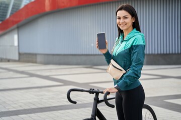 Obraz na płótnie Canvas Smiling positive lady demonstrating smartphone in the city
