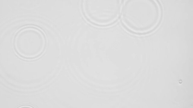 Up close, top view, Slow motion various waves of the water surface hitting the sun's rays, making them sparkle according to different patterns on a gray background video 4K.
