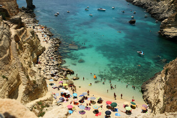 Santa Cesarea Terme, Puglia, Italy - july 14, 2017: Bay of Porto Miggiano. The amazing view of the deep blue and cerulean sea and mediterranean beach. Rocky landscape. Salento Adriatic sea coast