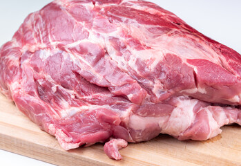 Large piece of raw pork neck on choping board .