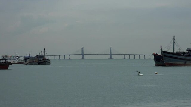 zoom out from penang road bridge over the foggy river.