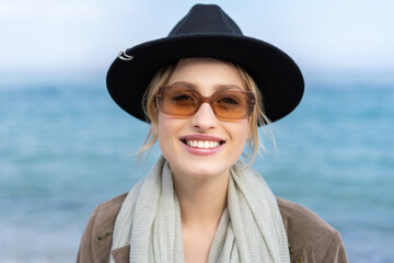 Portrait of a happy smiling women in the glasses and hat on the beach 