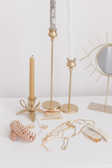 Boho accessory, interior details. Modern gold jewellery, hair clips with vintage candles and mirror