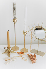 Boho accessory, interior details. Modern gold jewellery, hair clips with vintage candles and mirror