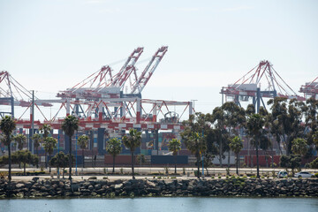 Fototapeta na wymiar Cargo cranes offload cargo ships at a port.