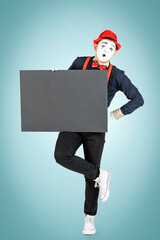 A happy pantomime man holds a black board on a blue background