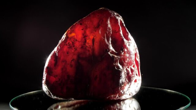 Precious red amber stone of strange form lies closeup