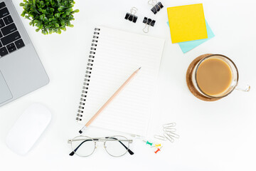 Top view of a desk with a laptop, coffee cup , mouse, notebooks, pot-it, , glasses and elament isolated on white background