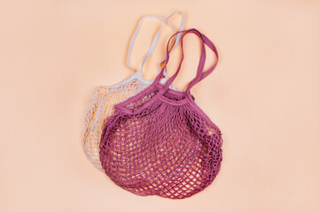 Flatlay with mesh string produce bags isolated on beige background. Zero waste concept.