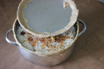 Mutton biriyani inside the open pot after breaking the sealed edges. The edges were seled for slow cooking the rice.