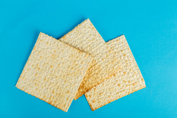 Matzo plates laid out in any shape on a blue background.