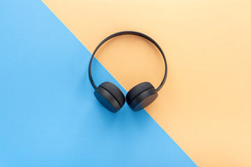 Headphones Wireless Black color isolated on a blue and orange background 