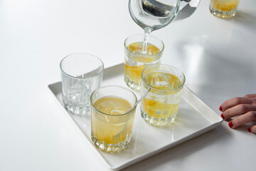 glasses of freshly poured charcoal filtered water on a table. Cold yuzu, citrus tea summer drink.