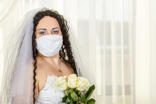 A Jewish bride in a synagogue before a huppa ceremony during a pandemic,  wearing a medical mask and a bouquet of flowers, waits for the groom. Stock  Photo | Adobe Stock