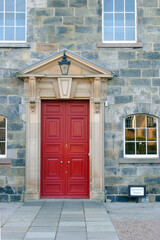 Old Stone Building & Red Wooden Entrance Door with Pediment and Stone Surround 