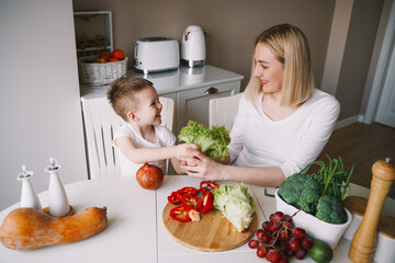 mother with little son preparing a salad of fresh vegetables