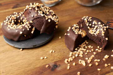 Cocoa donuts with almonds and nuts in a black and brown background horizontal