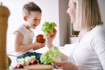 Obraz na płótnie Canvas mother with little son preparing a salad of fresh vegetables
