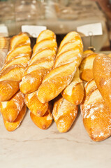 top, front view, medium distance of loaves of freshly baked French bread, on display and for sale at a tropical farmers market
