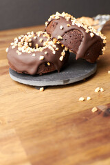 Cocoa donuts with almonds and nuts in a black and brown background vertical