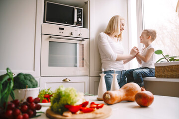 mom with little son in the white kitchen