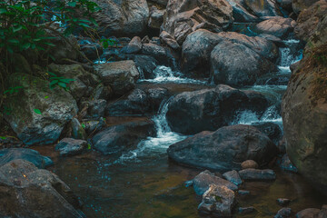 The wild landscape of a rivers with rocks. The river flows through the fall of the Velo de Novia waterfall. View of the rocks of the forest river in the ecological park 