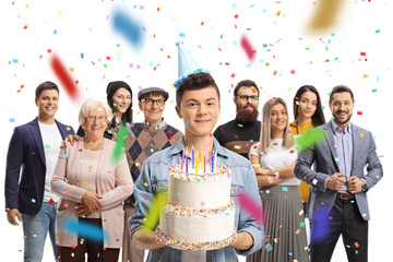 Birthday party with a male teenager holding a cake with his family around