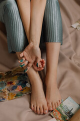 Legs and hands of young european girl sitting on beige background