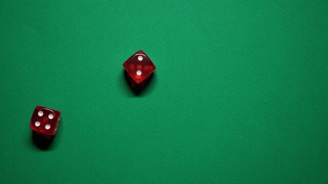 Red dice falling on green table. The Numbers 4 and 2 Appear on the Dice.