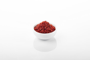 Chili pepper flakes. Chili pepper flakes in white bowl, on white background.
